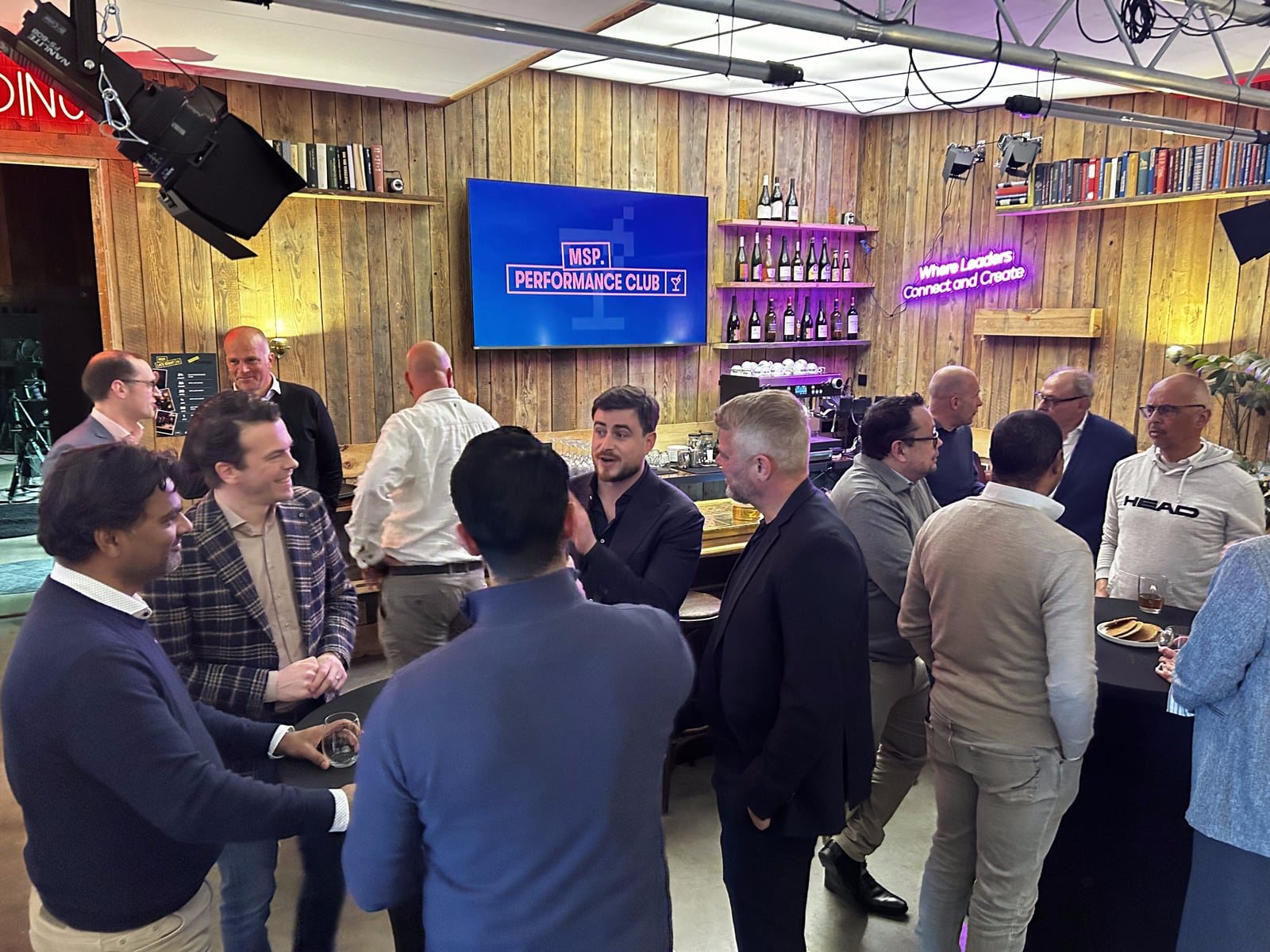Groepje bezoekers in gesprek voor het scherm van MSP Performance Club
