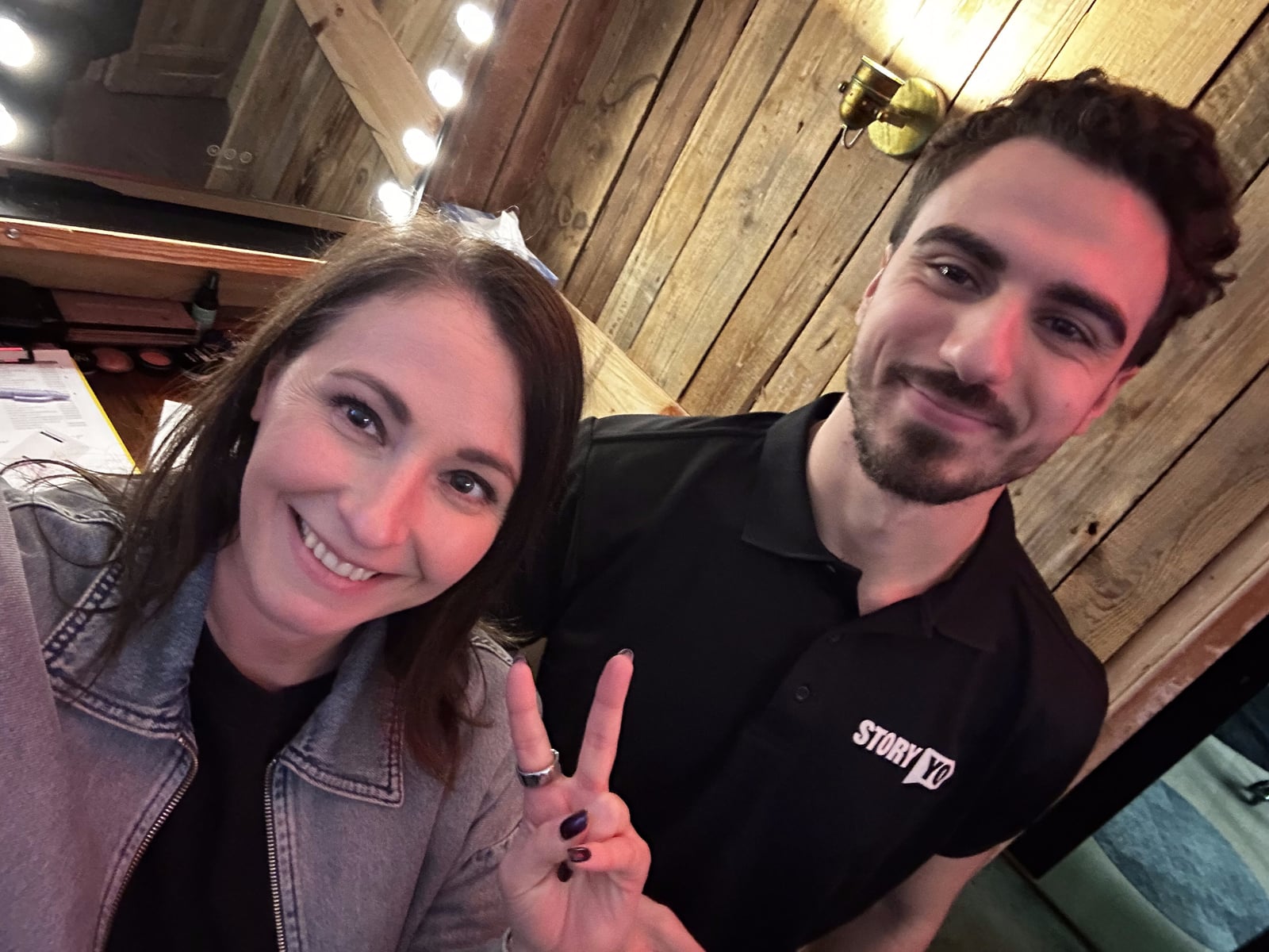 Twee bezoekers poseren voor de camera, een van hen in een StoryYo-shirt